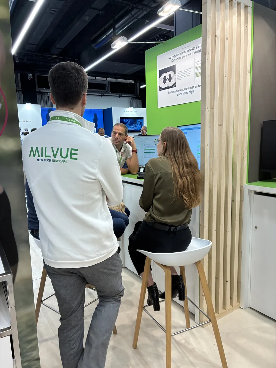A demo at a Milvue booth station at JFR 2026, under a TechCare Report panel