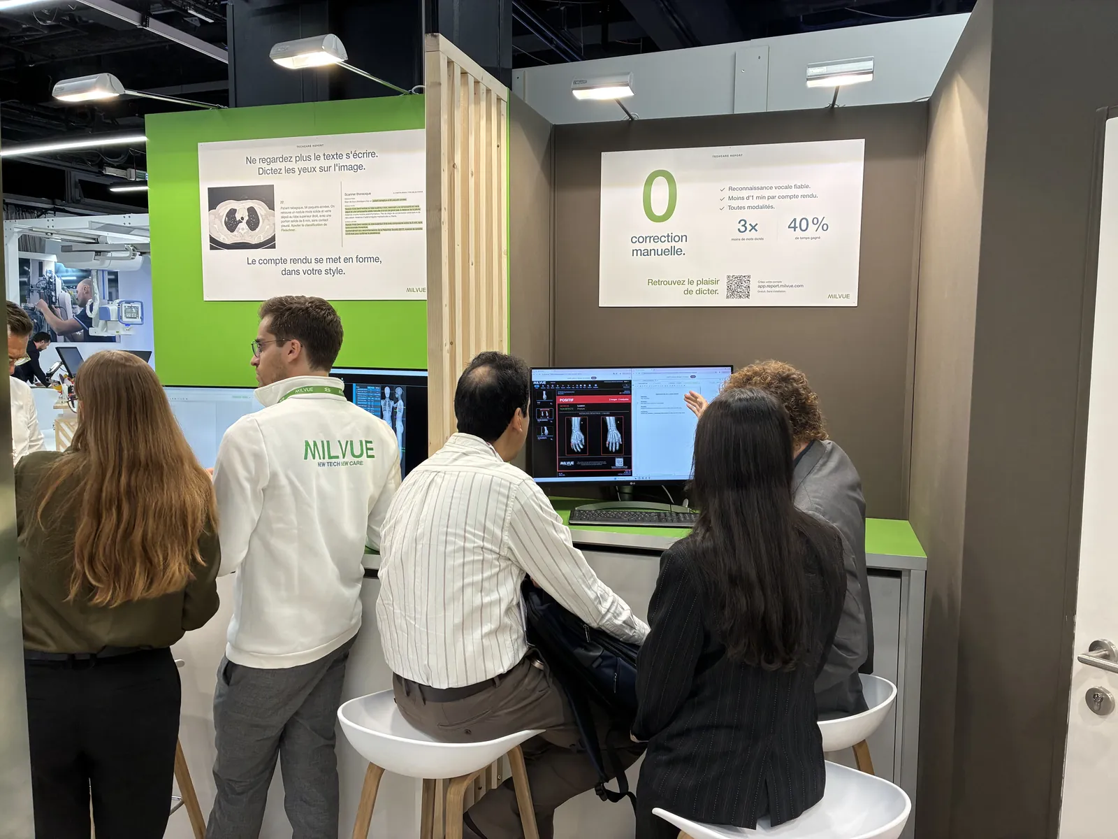 Visitors at the demo stations of the Milvue booth at JFR 2026, under two TechCare Report panels