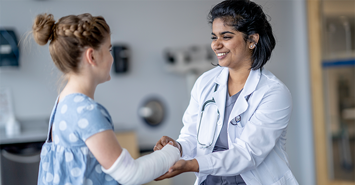 Femme médecin et petite fille avec bras dans le plâtre